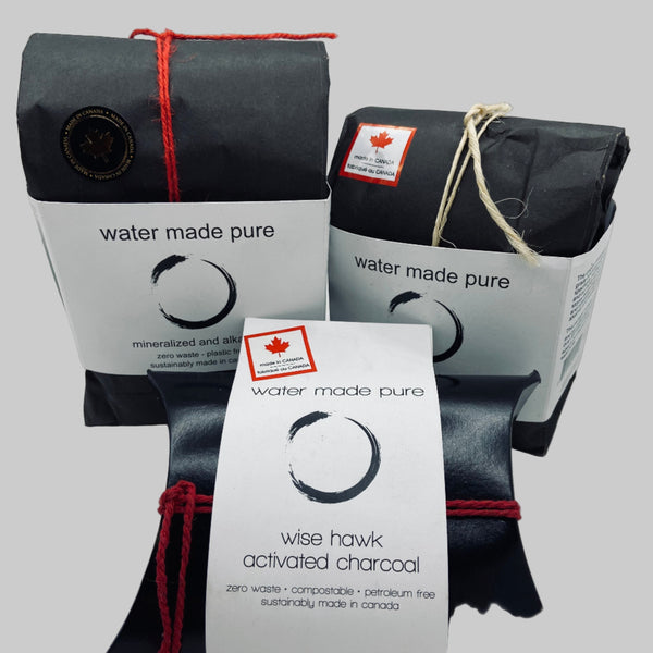 Activated charcoal packages with 'water made pure' and 'wise hawk' branding on a white background.